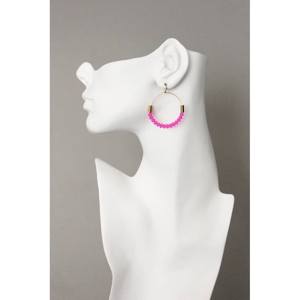 Pink beaded hoop earring on a white mannequin ear against a gray background