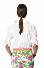 Person wearing a white shirt and colorful floral pants on a white background