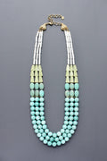 Triple strand Necklace with turquoise beads and amazonite with gold accents flatlay on grey background