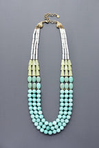 Triple strand Necklace with turquoise beads and amazonite with gold accents flatlay on grey background