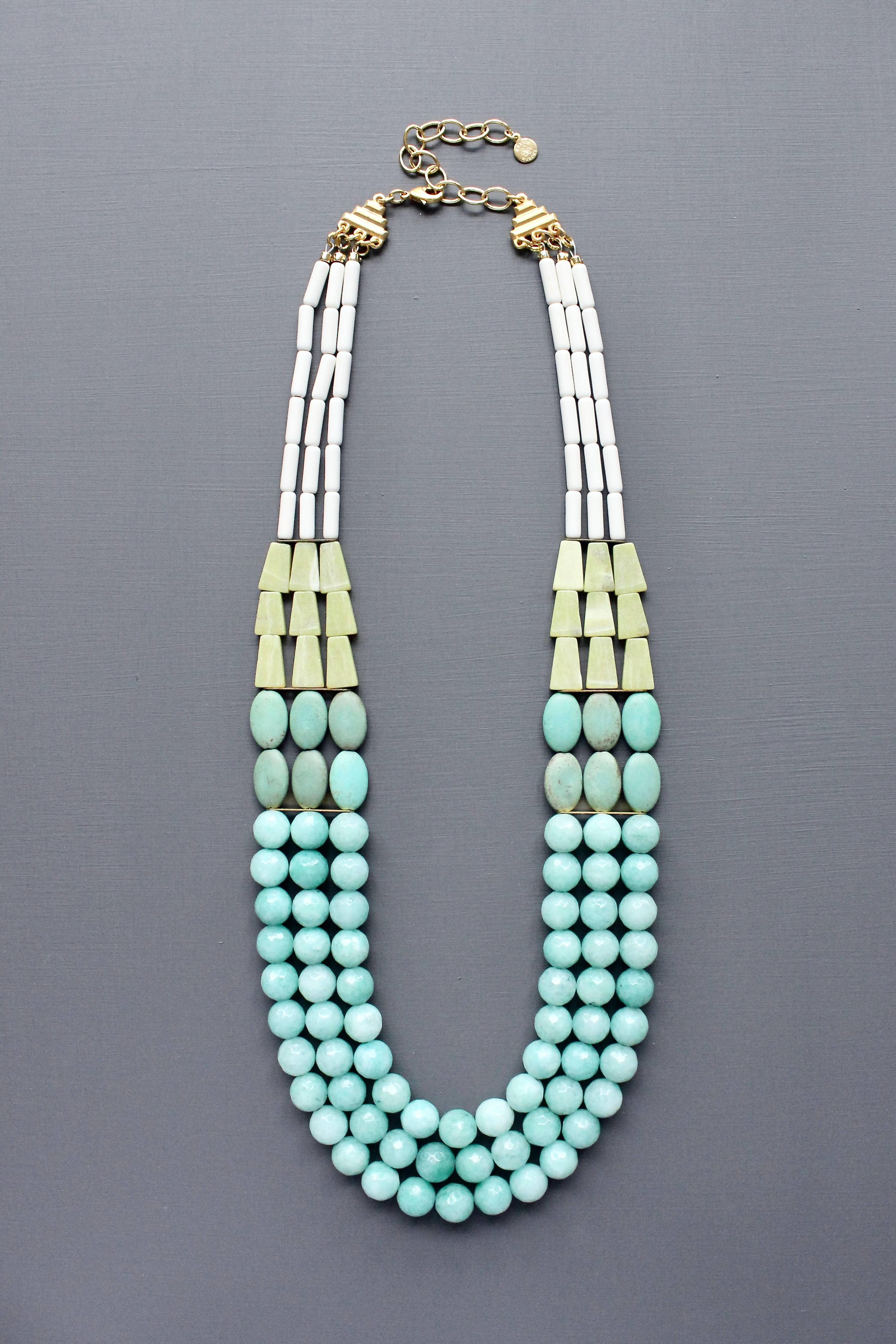Triple strand Necklace with turquoise beads and amazonite with gold accents flatlay on grey background