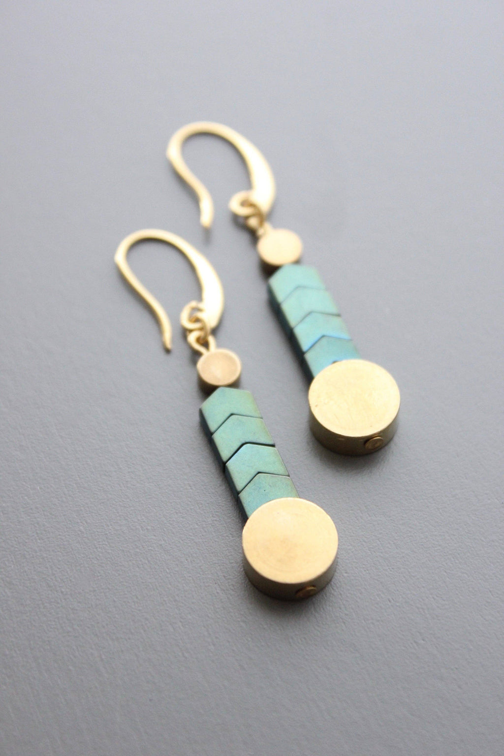 Paire of turquoise and brass herringbone earrings laying down