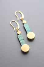 Paire of turquoise and brass herringbone earrings laying down