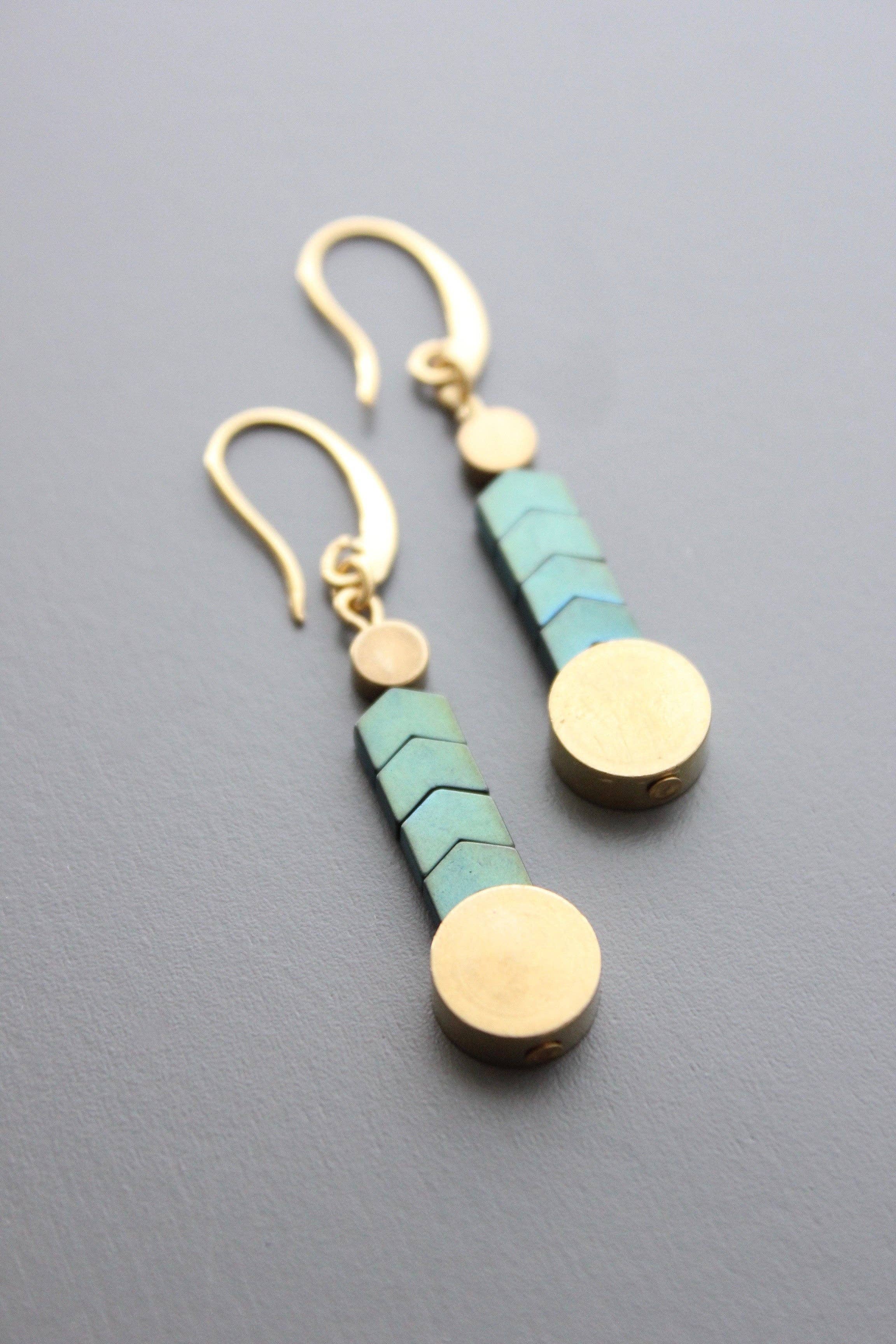 Paire of turquoise and brass herringbone earrings laying down