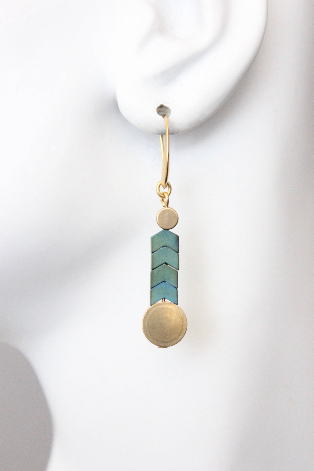 Earring with turquoise cylindrical bead and gold sphere on white background